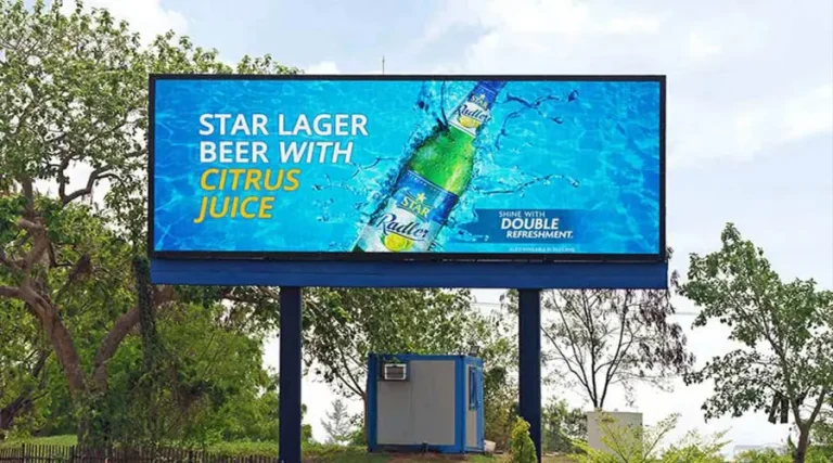 Outdoor digital billboard displaying a bright advertisement for Star Lager Beer with citrus juice on a large SMD LED screen.