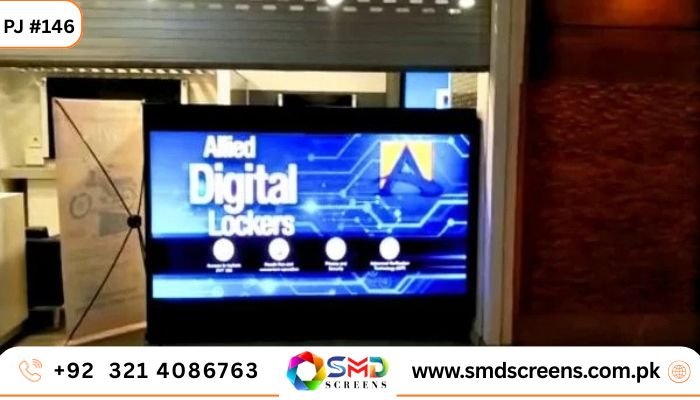 A small indoor LED screen at eye-level displaying a blue and black advertisement for "Allied Digital Lockers" with feature icons.