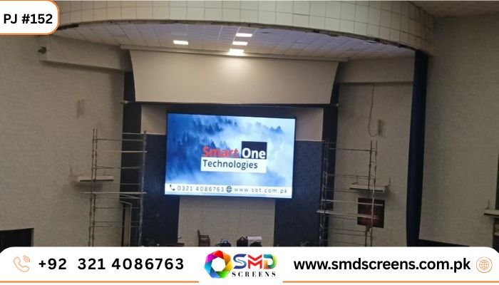 Indoor SMD screen installed on a stage at a hall with scaffolding on both sides and a large display showing Smart One Technologies content.